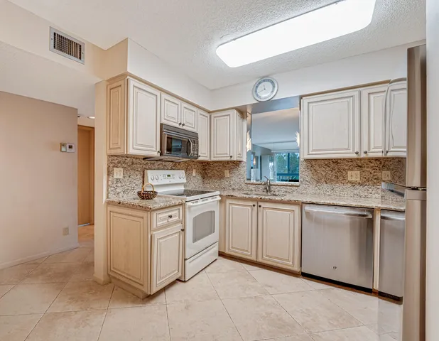 a kitchen with stainless steel appliances granite countertop a stove top oven a sink and dishwasher