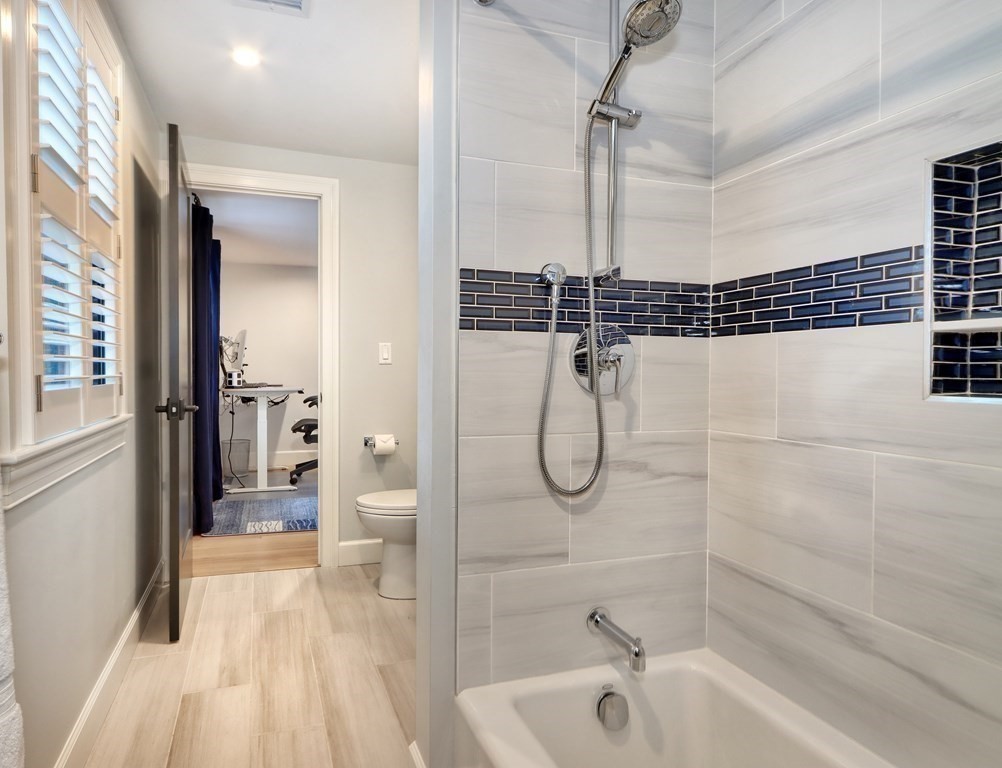 27 Cabot Street Winchester, MA 01890 - Photo 31 of 42 a bathroom with a granite countertop shower sink and mirror