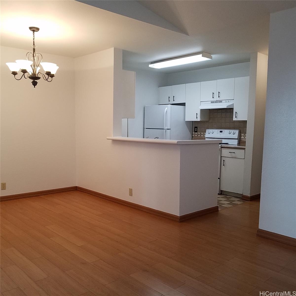 a kitchen with stainless steel appliances granite countertop a sink a stove a refrigerator and microwave with wooden floor