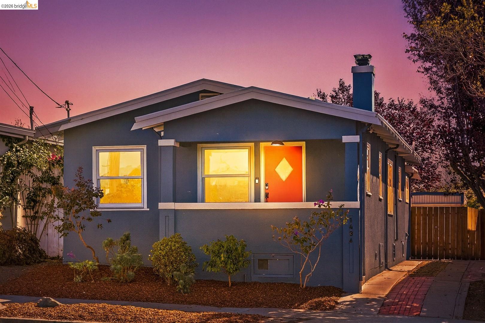 View of front of house featuring a chimney and stucco siding