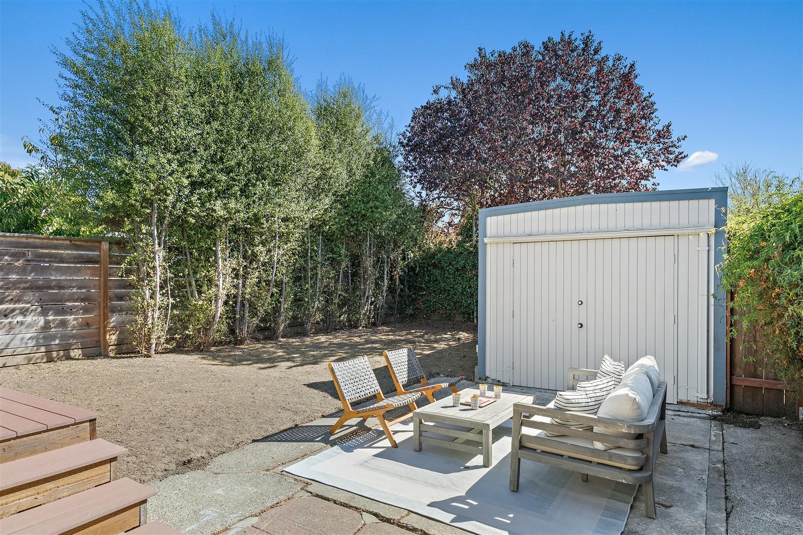 1436 Delaware Street Berkeley, CA 94702 - Photo 26 of 60 Fenced backyard with a patio, a storage unit, and outdoor lounge area