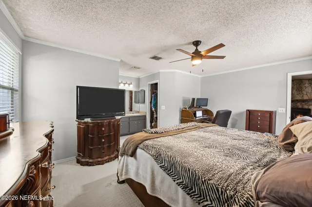 a bedroom with bed and a flat tv screen on dresser