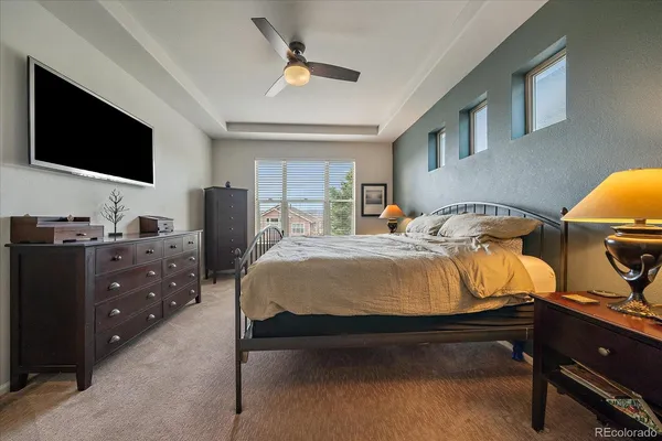 a bedroom with a bed and a flat tv screen on dresser
