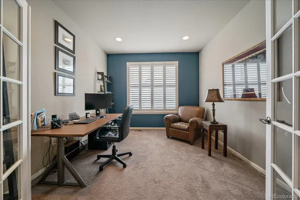 a view of a workspace with furniture and a window