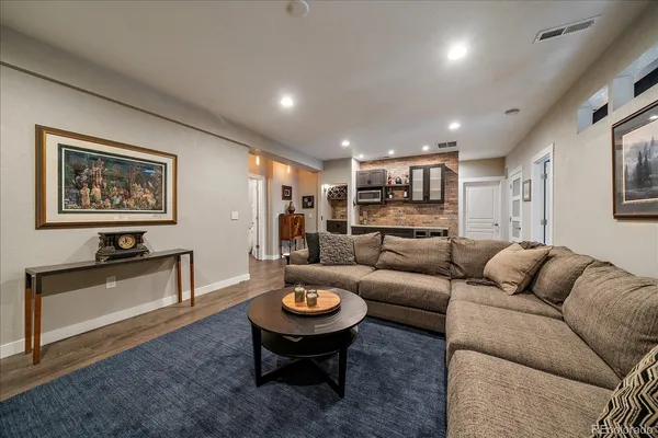 a living room with furniture kitchen view and a window
