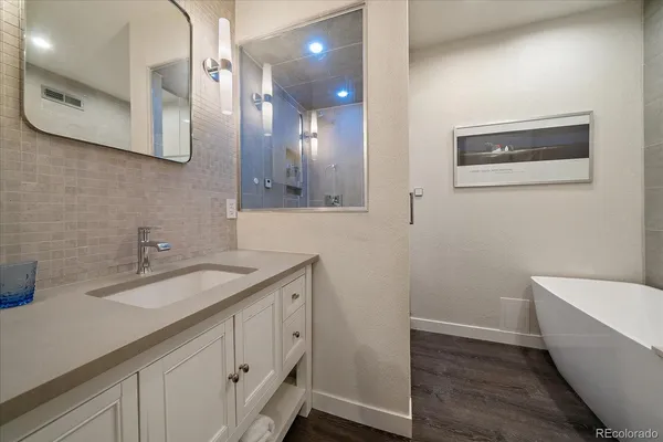a bathroom with a granite countertop sink a toilet and a mirror