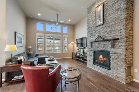 a living room with furniture a fireplace and a large window