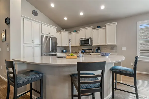 a kitchen with kitchen island white cabinets and stainless steel appliances