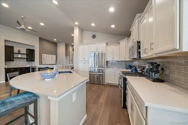 a kitchen with a sink a stove a refrigerator and white cabinets