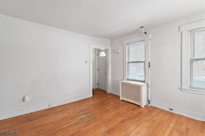 354 Hayward Street Orange, NJ 07050 - Photo 13 of 18 a view of an empty room with window and wooden floor