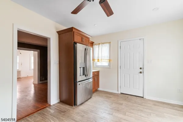 a view of a hallway with wooden floor and cabinet