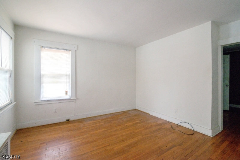 354 Hayward Street Orange, NJ 07050 - Photo 7 of 18 an empty room with wooden floor and windows