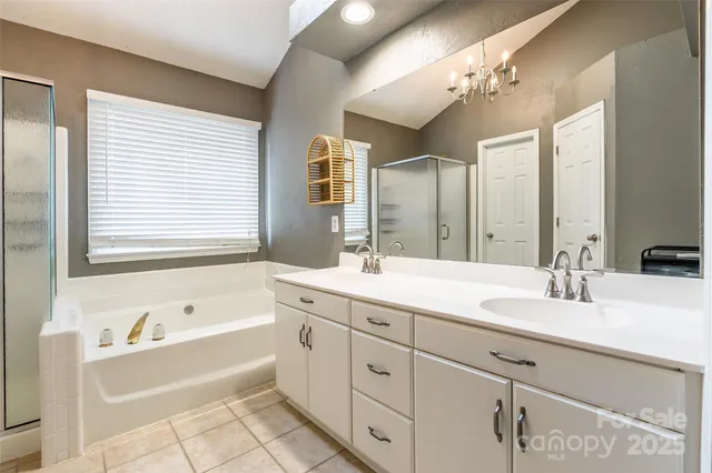 a bathroom with a granite countertop sink mirror and bathtub