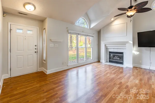 a view of empty room with fireplace and wooden floor