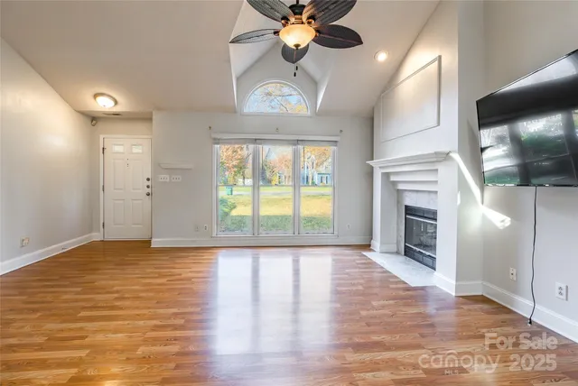 a view of an empty room with a fireplace and a window