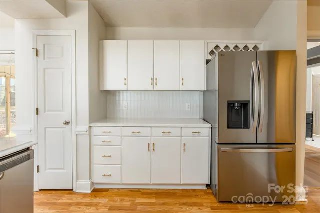 a kitchen with cabinets stainless steel appliances and a window