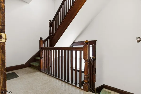 a view of staircase with railing and white walls