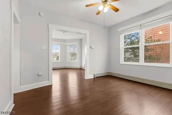 an empty room with wooden floor and windows