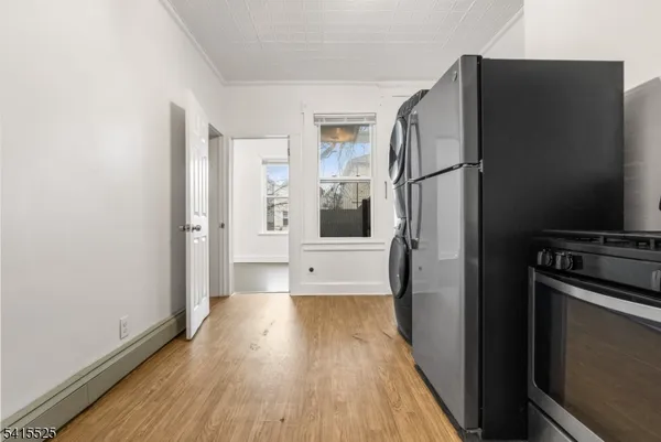 a view of a refrigerator in kitchen and wooden floor