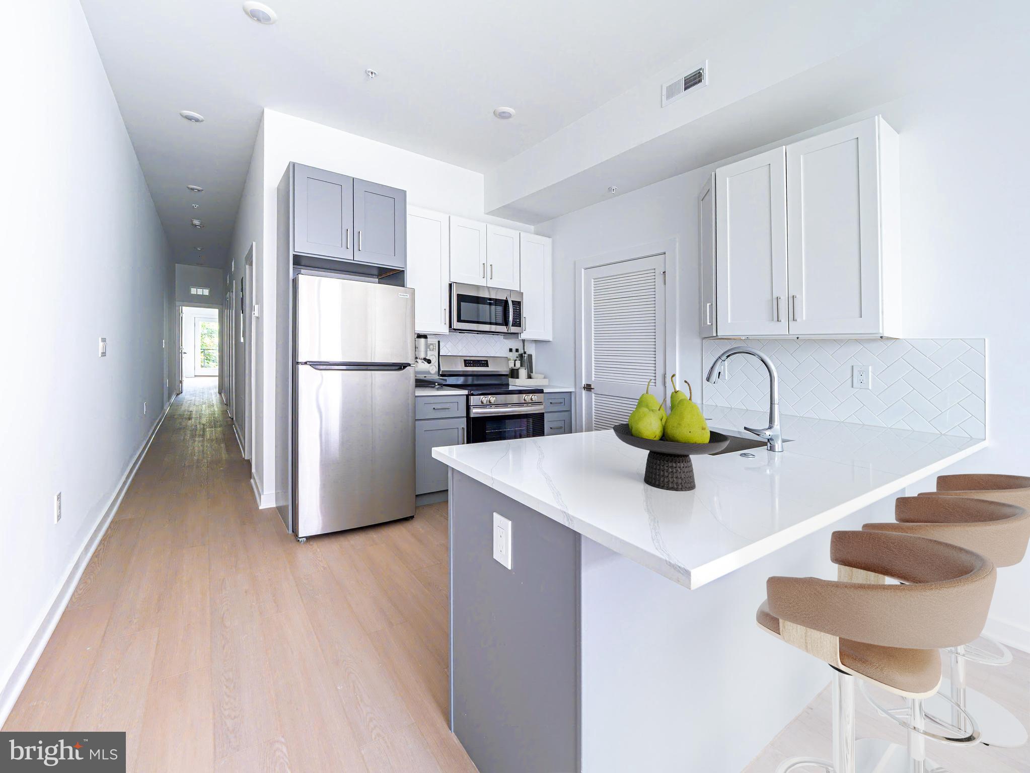 2403-2407 West Thompson Street, Unit 3 Philadelphia, PA 19121 - Photo 2 of 13 a kitchen with a refrigerator a stove a sink a counter top space and cabinets