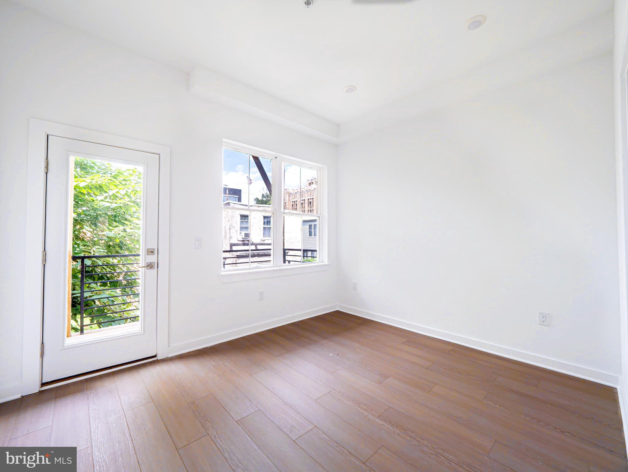 2403-2407 West Thompson Street, Unit 3 Philadelphia, PA 19121 - Photo 10 of 13 an empty room with wooden floor and windows