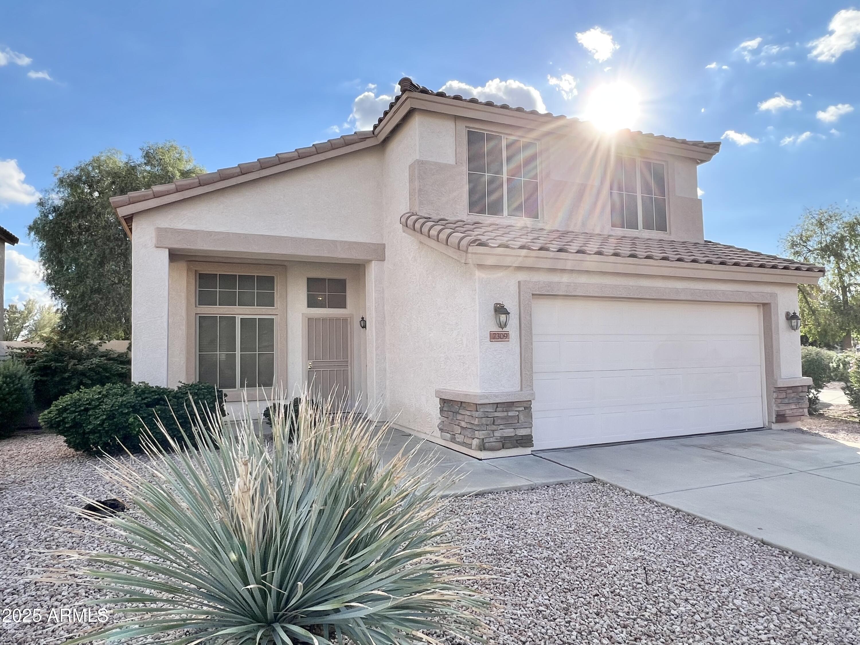 7309 West Mohawk Lane Glendale, AZ 85308 - Photo 1 of 24 a front view of a house with a garden