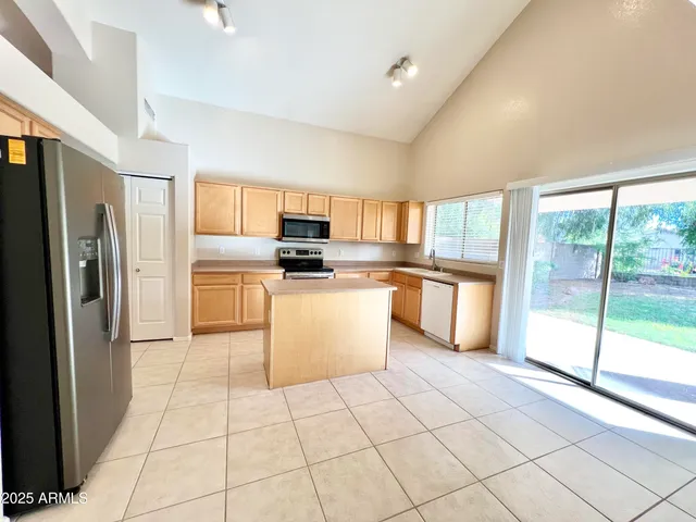 a kitchen with a refrigerator a stove top oven and white cabinets