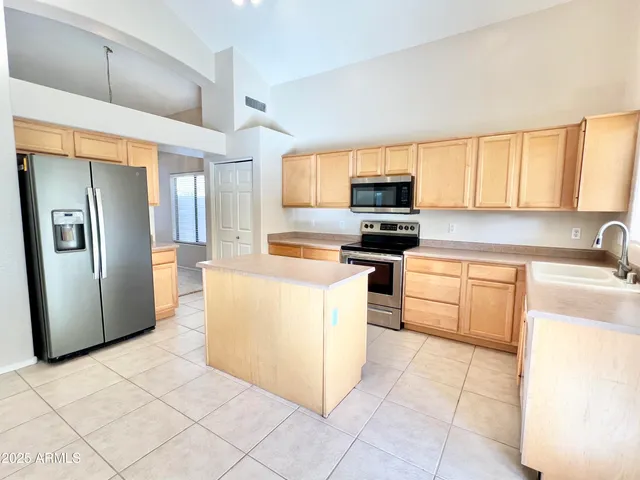 a kitchen with stainless steel appliances a refrigerator sink and microwave