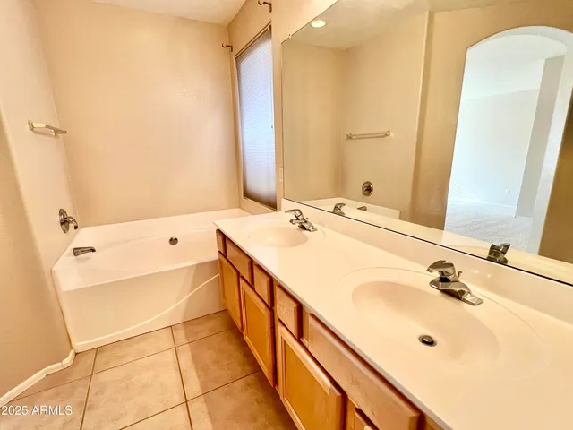 a bathroom with a tub sink and mirror