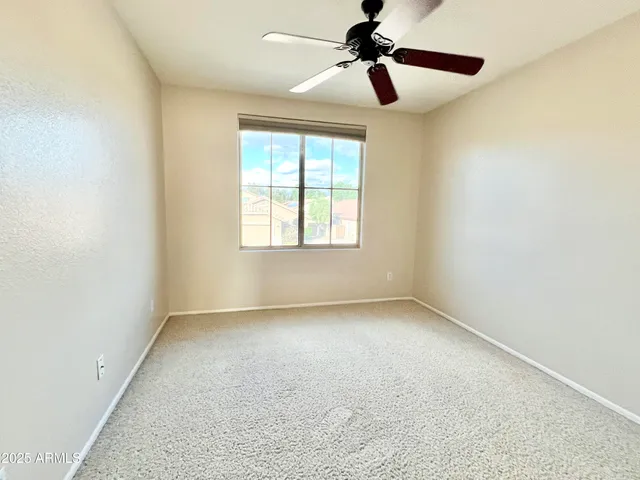 a view of room with a ceiling fan and window