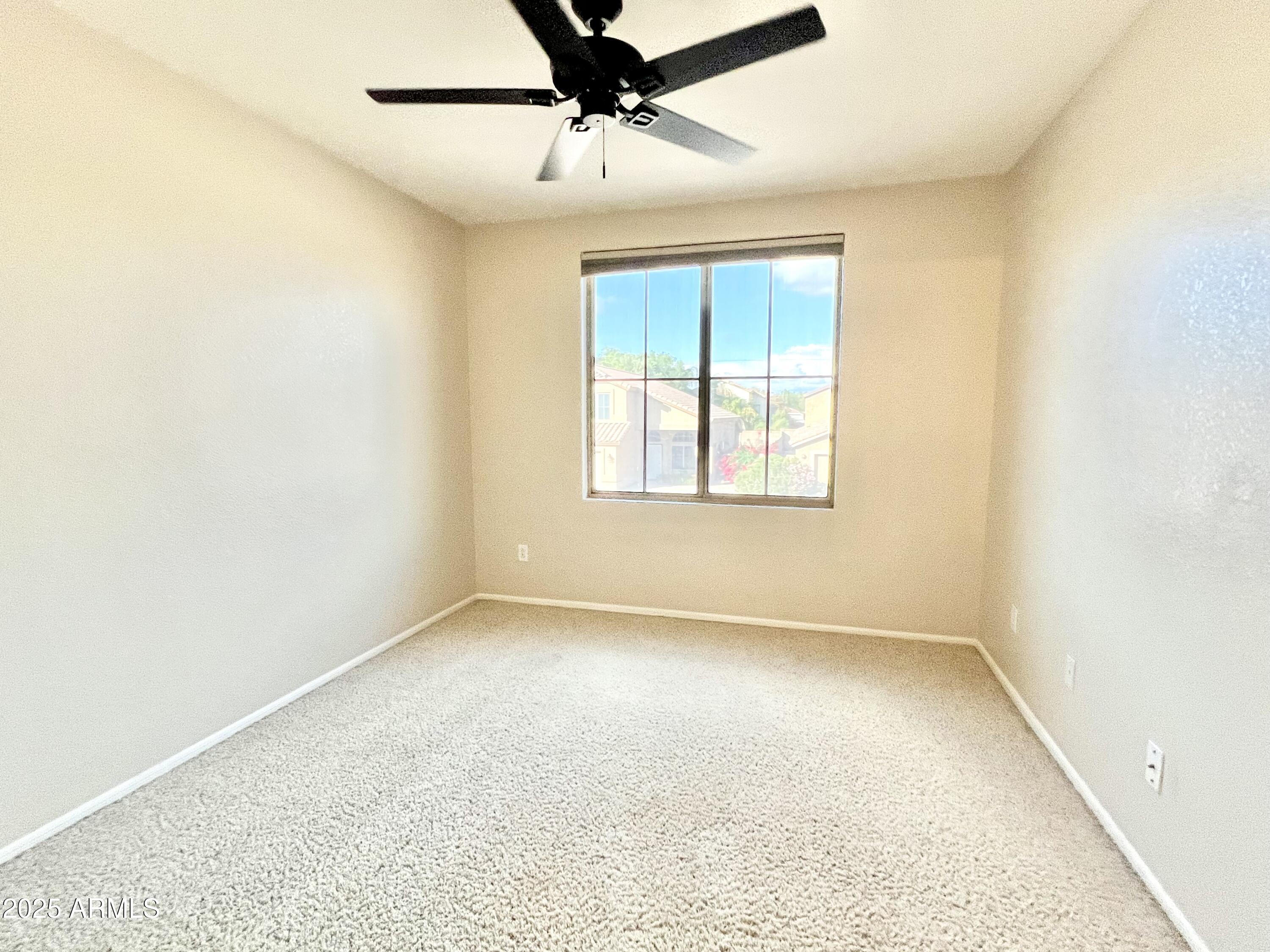 7309 West Mohawk Lane Glendale, AZ 85308 - Photo 23 of 24 an empty room with a window and a ceiling fan