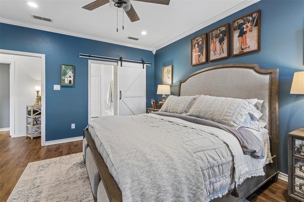 10176 Country View Lane Forney, TX 75126 - Photo 19 of 40 a bedroom with a large bed and a chandelier