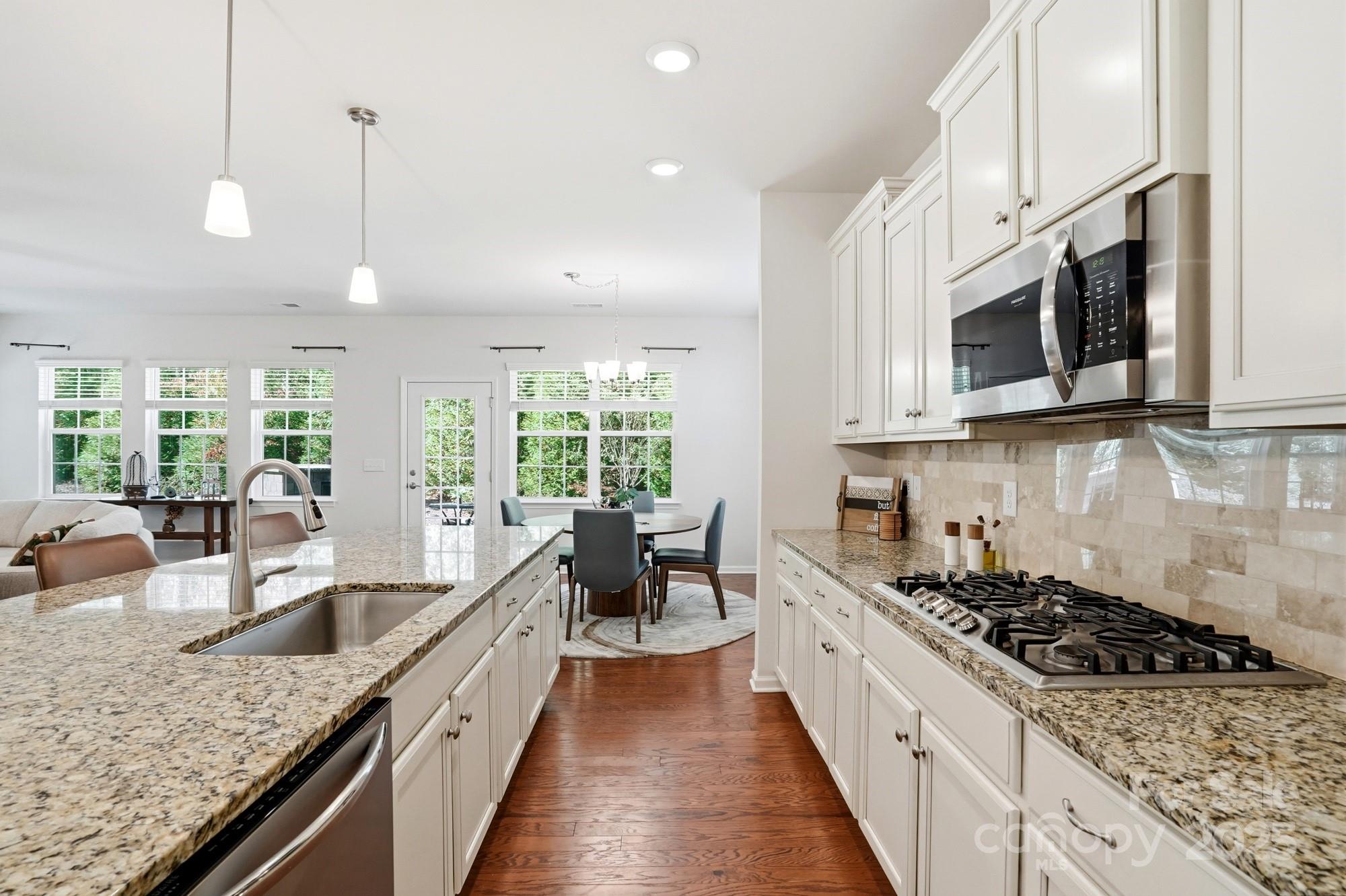 128 Van Gogh Trail Mount Holly, NC 28120 - Photo 16 of 48 a large kitchen with stainless steel appliances granite countertop a lot of counter space and wooden floors