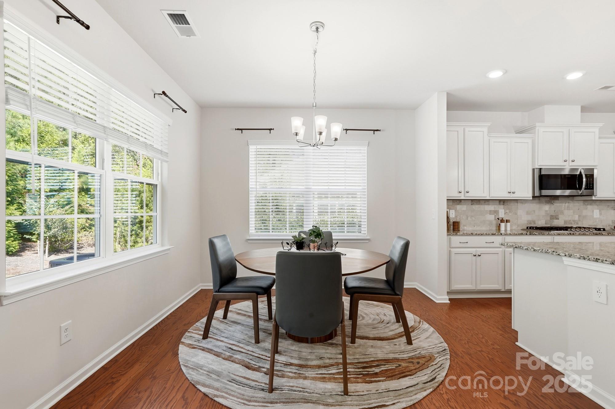 128 Van Gogh Trail Mount Holly, NC 28120 - Photo 21 of 48 a dining room with wooden floor and a chandelier