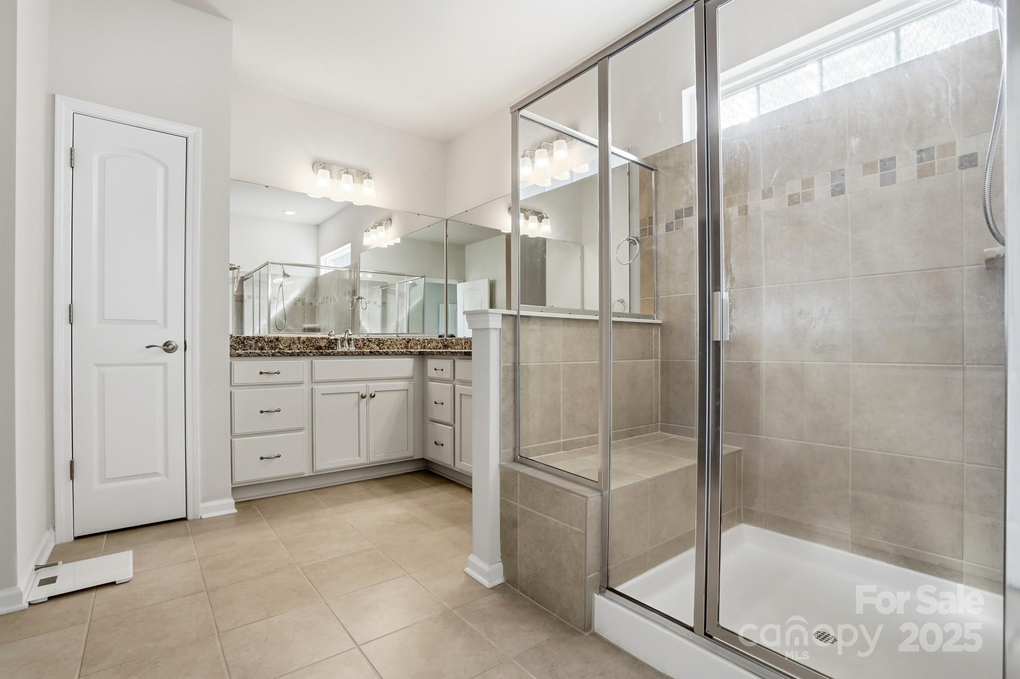 128 Van Gogh Trail Mount Holly, NC 28120 - Photo 26 of 48 a bathroom with a granite countertop sink a mirror and a shower