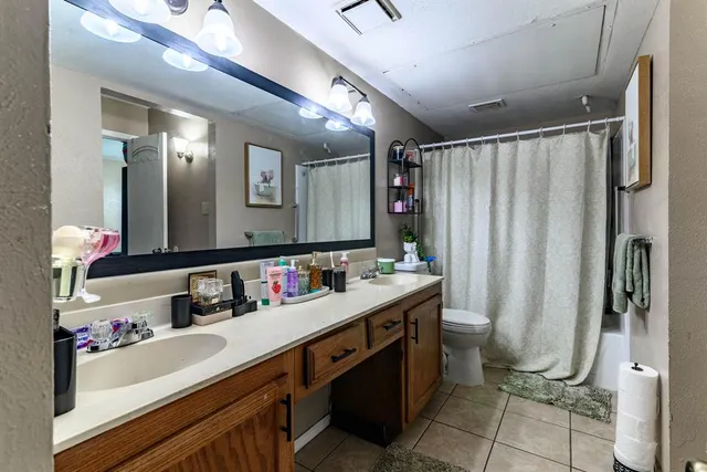a bathroom with a double vanity sink mirror and shower