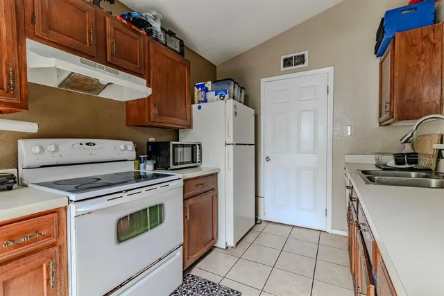 a kitchen with a refrigerator a stove top oven and a sink