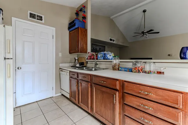 a kitchen with stainless steel appliances granite countertop a sink and a refrigerator