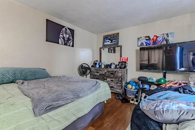 a bedroom with a bed a dresser and book kitchen