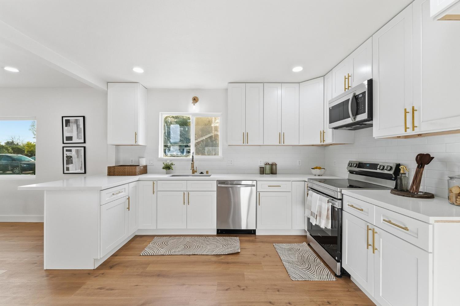 430 Laurel Avenue Modesto, CA 95351 - Photo 13 of 28 a kitchen with stainless steel appliances granite countertop a stove top oven a sink a refrigerator and white cabinets