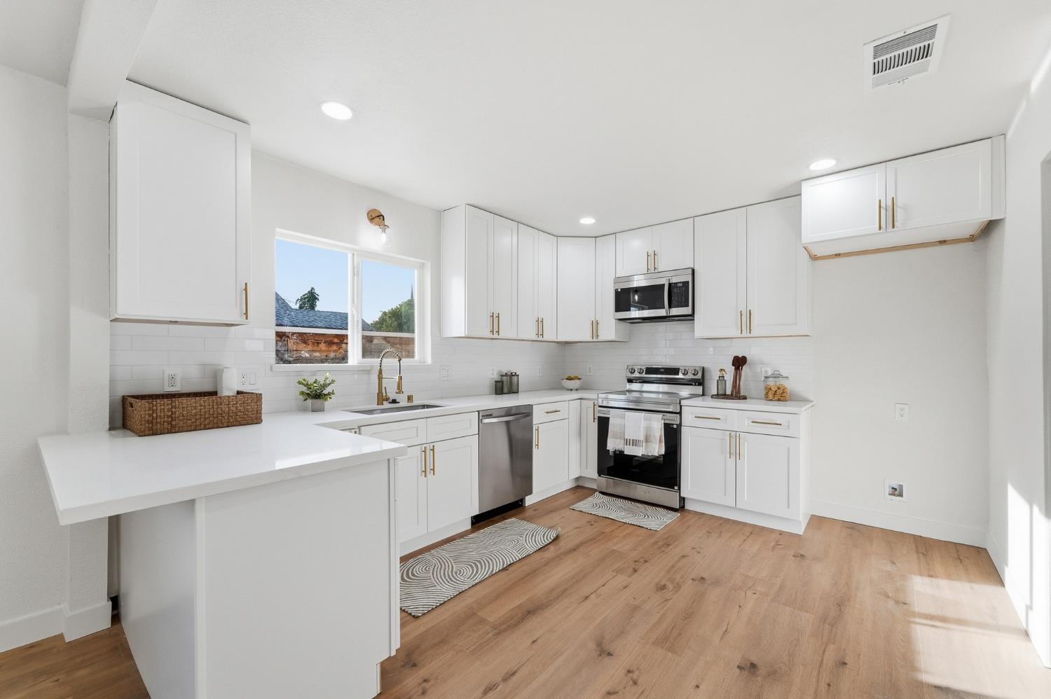 430 Laurel Avenue Modesto, CA 95351 - Photo 15 of 28 a kitchen with a sink cabinets and wooden floor