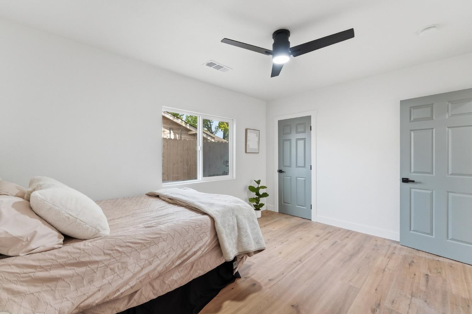 430 Laurel Avenue Modesto, CA 95351 - Photo 7 of 28 a bedroom with a large bed and a ceiling fan