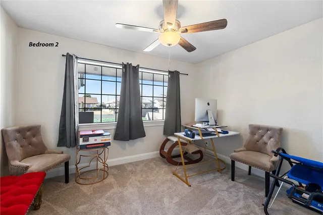 a living room with furniture a ceiling fan and a window