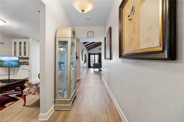 a view of a hallway with wooden floor and staircase