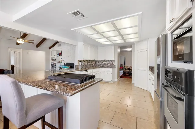a kitchen with stainless steel appliances granite countertop a stove refrigerator and a sink