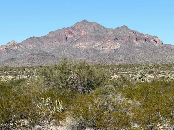 a view of a large mountain with mountains in the background
