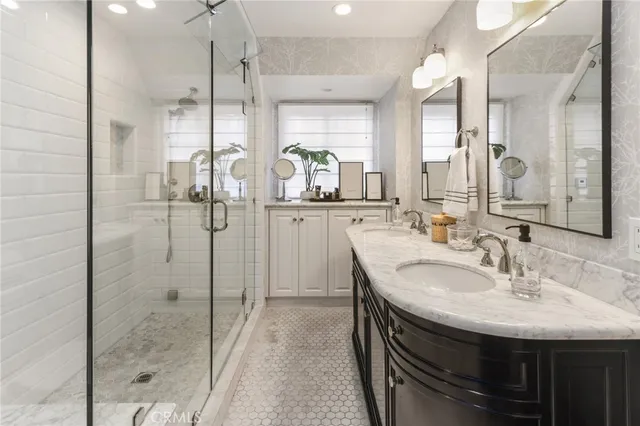 a bathroom with a sink shower and a mirror
