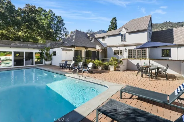 a view of a house with swimming pool and sitting area
