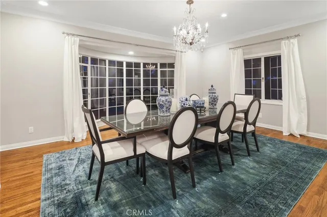 a dining room with furniture a chandelier and wooden floor