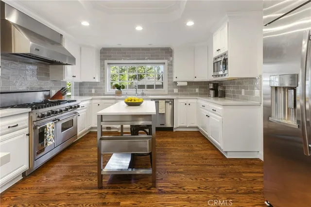 a kitchen with a stove a sink and a wooden floors